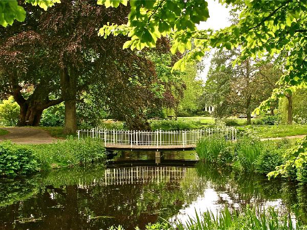 Slingerpaadjes en smalle brugjes leiden u door het 19e eeuwse deel van het park.